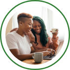 A couple sip coffee together while using a laptop. 